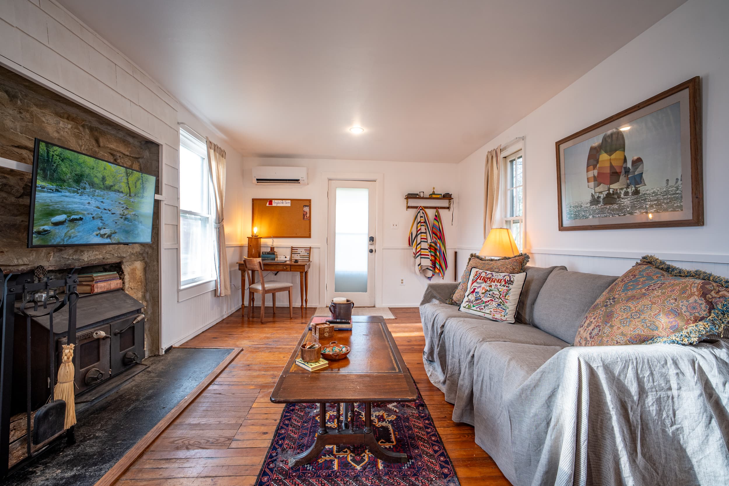 Living room with hardwood floors, wood stove, and eclectic furnishings