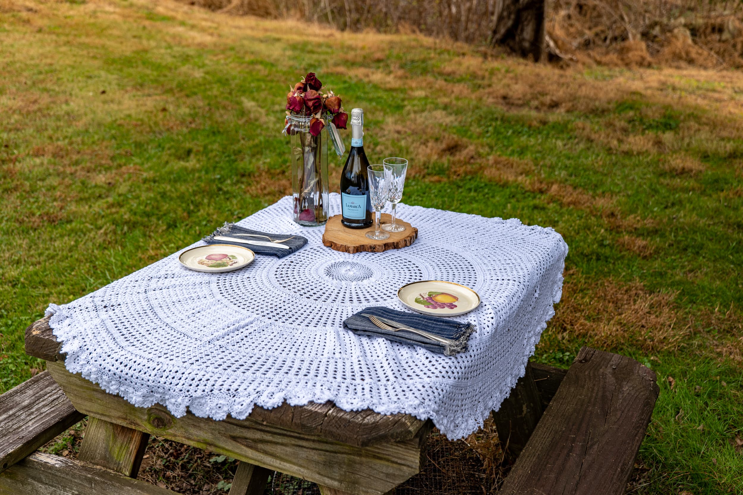 Outdoor dining with crocheted tablecloth and champagne
